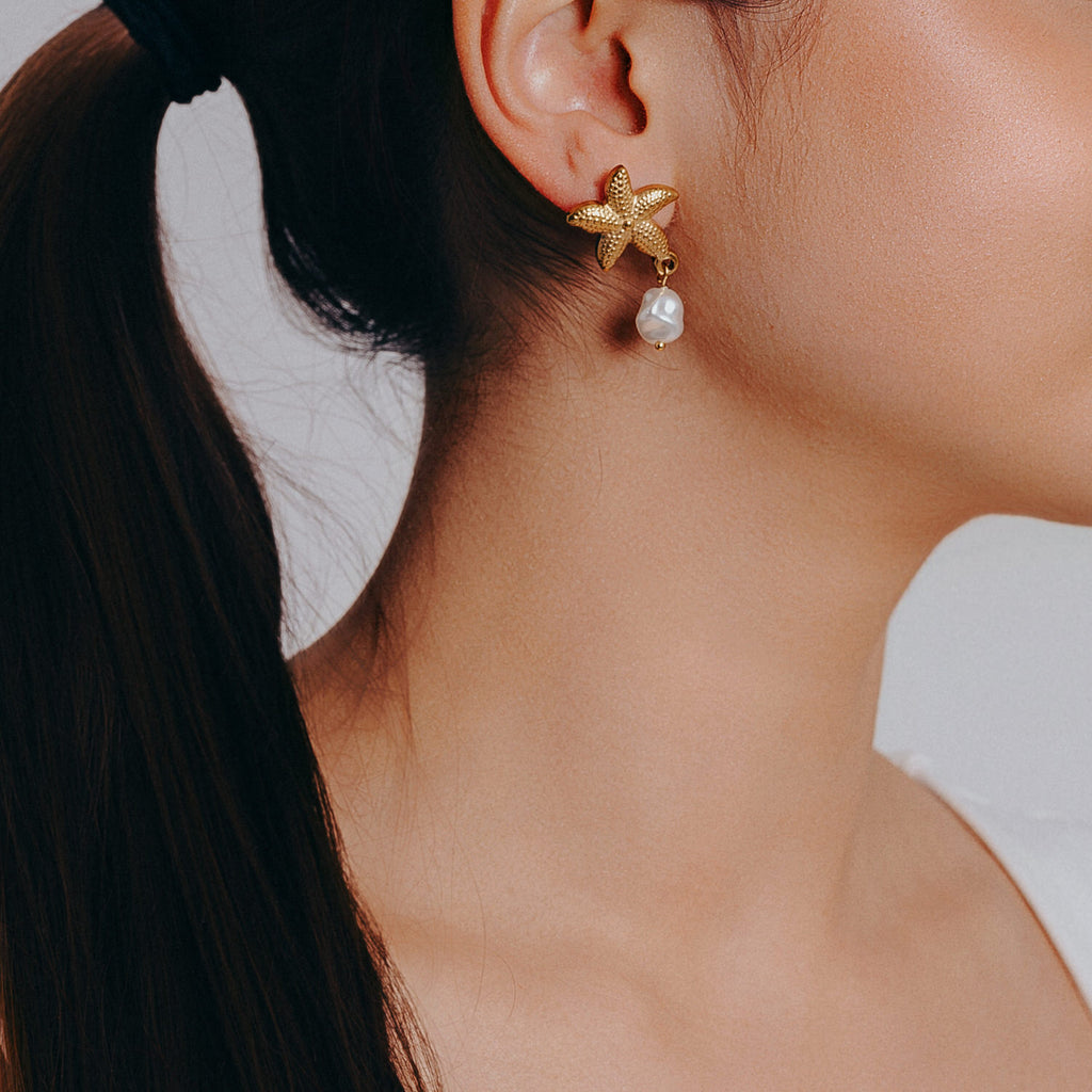 sjöstjärna örhange med pärla bärs av modell