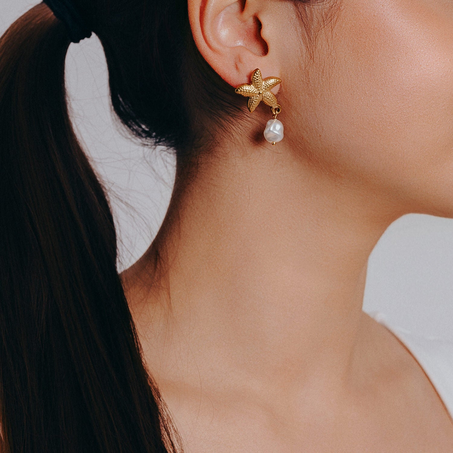 sjöstjärna örhange med pärla bärs av modell